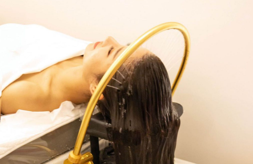 Water flowing over hair during a head spa treatment